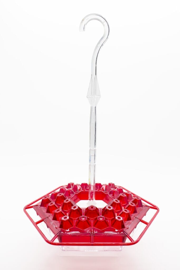 A red umbrella with a clear handle and a bunch of red beads