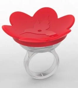 A red bird feeder sitting on top of a ring.