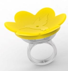 A yellow ring with a flower shaped object on top of it.