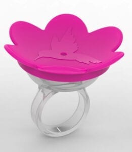 A pink ring with a flower shaped dish on top of it.