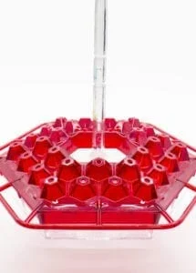 A red plastic tray with a glass tube in it.