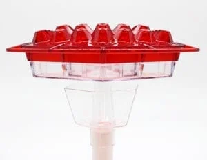 A red plastic container sitting on top of a white stand.