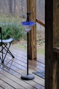 A blue and white lamp on top of a wooden deck.
