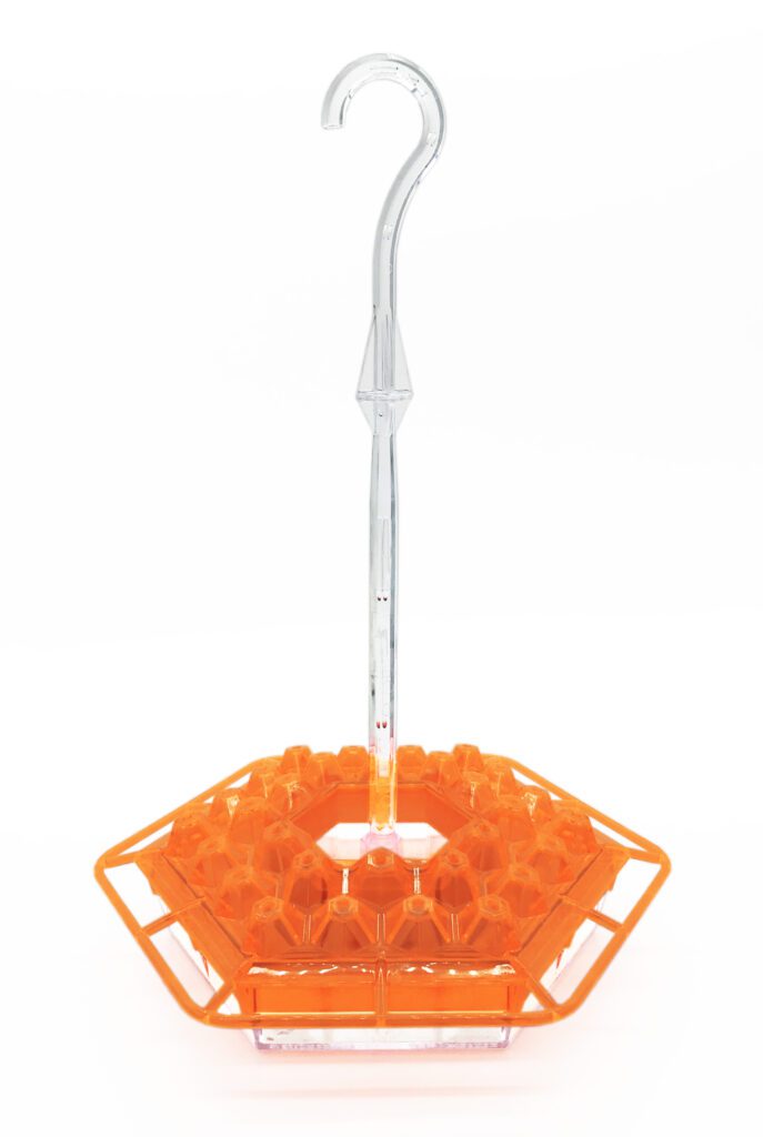A orange plastic basket with an umbrella attached to it.
