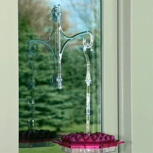 A window with a glass vase and water fountain.